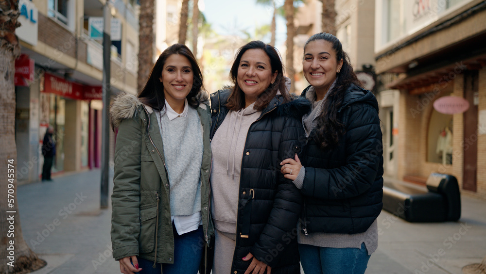 Fototapeta premium Mother and daugthers smiling confident hugging each other at street