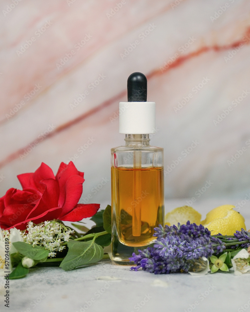 Floral face serum, natural perfume in transparent dropper bottle with lavender, rose, lemon, jasmine and elderflowers on marble background. Floral face serum, natural perfume in transparent dropper bottle with lavender, rose, lemon, jasmine and elderflowers on marble background.