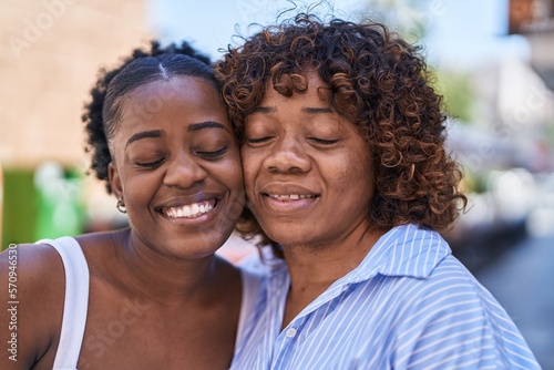 African american women mother and daughter standing together at street