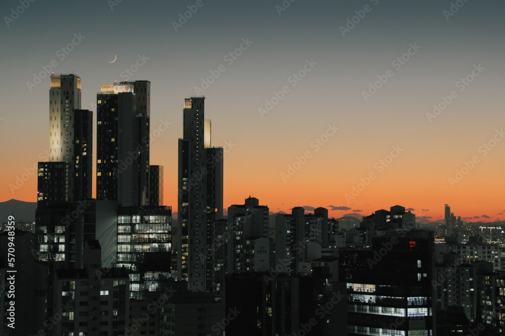 Obraz premium A wonderful landscape where the sun goes down and the gradient sky is visible through the buildings
