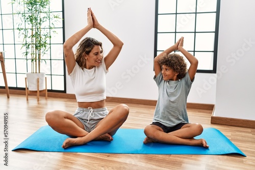 Mother and son smiling confident training yoga at sport center