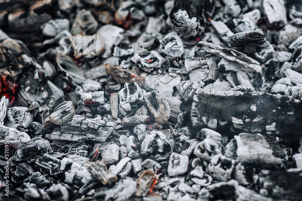 Photo of smoldering gray coals, burnt ash close-up in a fire. Photo of smoldering gray coals, burnt ash close-up in a fire.
