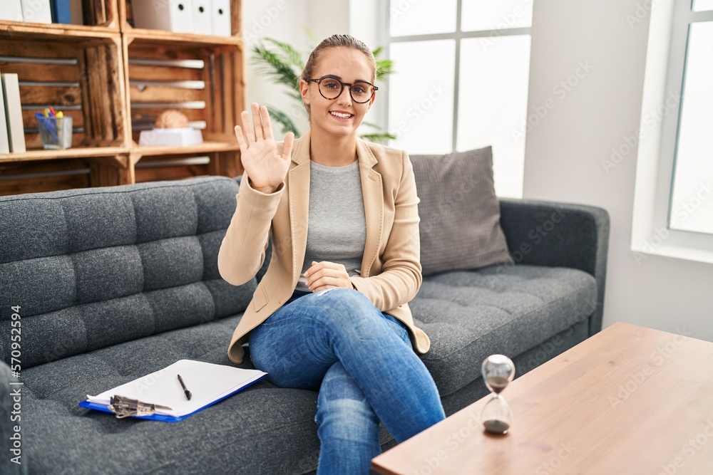 Young woman working at consultation office waiving saying hello happy and smiling, friendly welcome gesture Young woman working at consultation office waiving saying hello happy and smiling, friendly welcome gesture