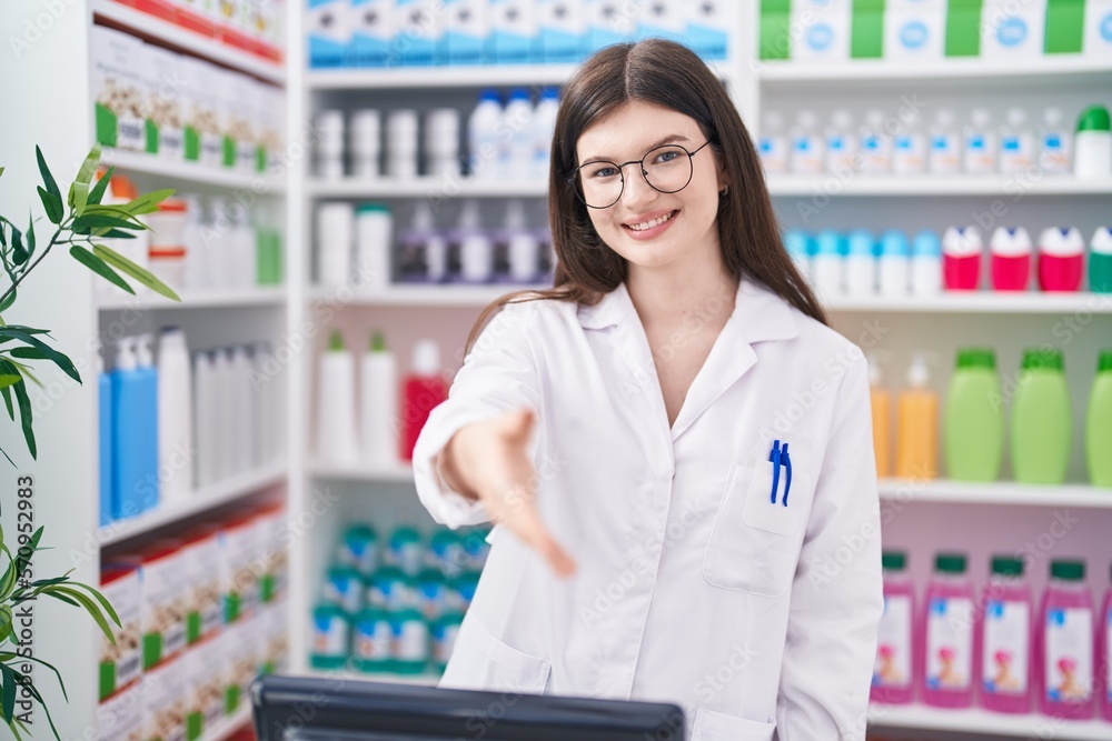 Young caucasian woman pharmacist smiling confident shake hand at pharmacy