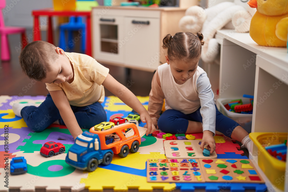 Two kids playing with cars toy and maths game sitting on floor at