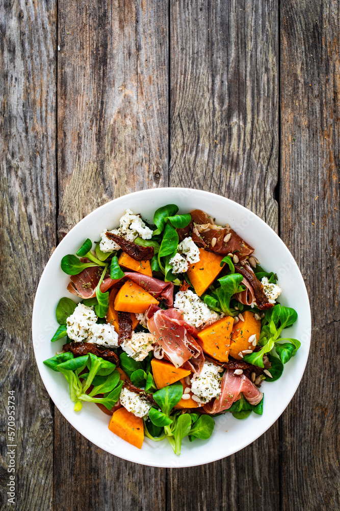Tasty salad - prosciutto crudo, sweet potatoes, smoked white cheese and fresh vegetables on wooden table
Tasty salad - prosciutto crudo, sweet potatoes, smoked white cheese and fresh vegetables on wooden table