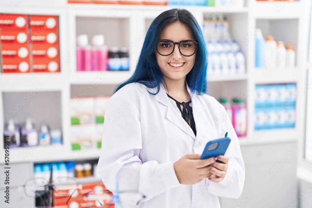 Young caucasian woman pharmacist using smartphone working at pharmacy