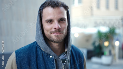 Young caucasian man standing wearing hoodie with serious expression at street