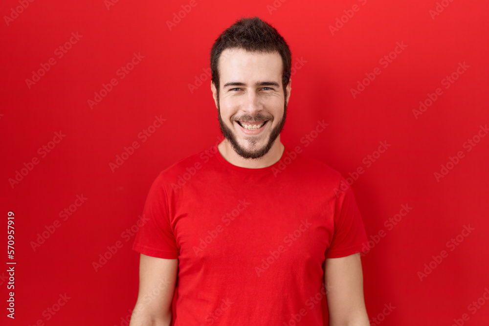 Young hispanic man wearing casual red t shirt with a happy and cool smile on face. lucky person. Young hispanic man wearing casual red t shirt with a happy and cool smile on face. lucky person.