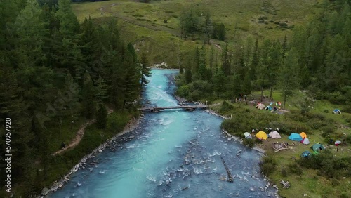 Aerial view of the turquoise river flowing in the coniferous forest photo