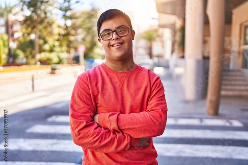 Obraz na plátně Down syndrome man smiling confident standing with arms crossed gesture at street