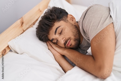 Young arab man lying on bed sleeping at bedroom