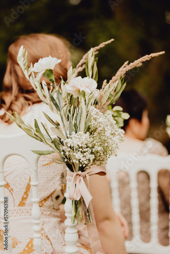 Bouquet de fleurs accroché aux chaises de la cérémonie de mariage photo