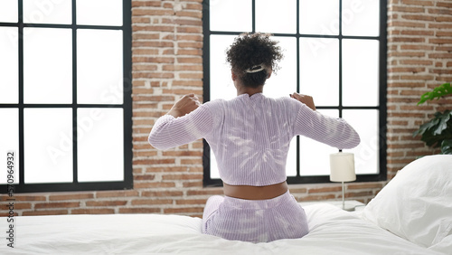 African american woman waking up stretching arms at bedroom