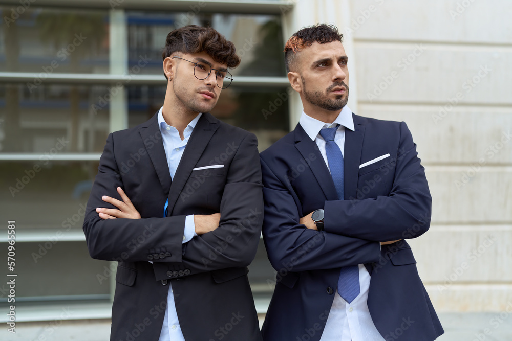 Two hispanic men business workers standing with arms crossed gesture at street Two hispanic men business workers standing with arms crossed gesture at street