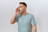 Hispanic man with beard standing over white background shouting and screaming loud to side with hand on mouth. communication concept.