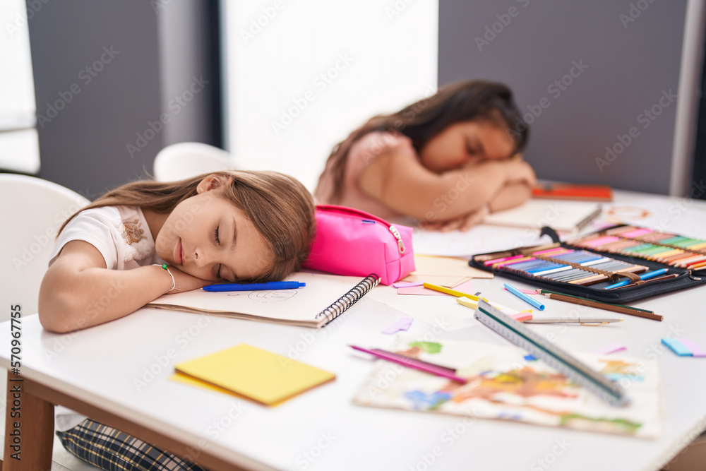 Two kids students sitting on table sleeping at classroom Two kids students sitting on table sleeping at classroom