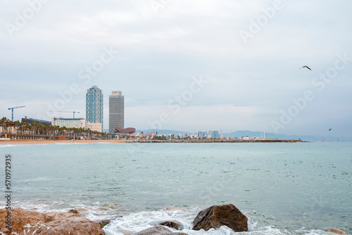 Beautiful seascape and distant view of Mapfre Tower and Hotel Arts skyscraper in Port Olympic on a cloudy day at Catalonia, Barcelona, Spain photo
