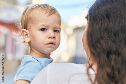 Mother and son standing with relaxed expression at street