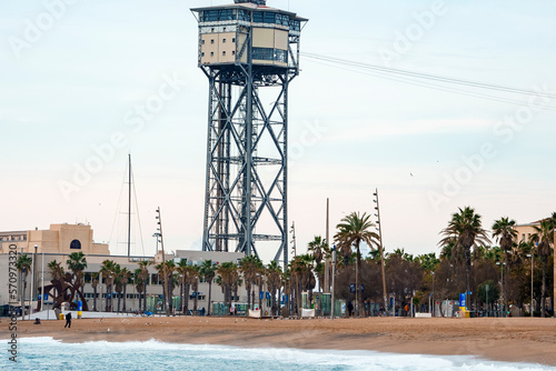 Tranquil view of palm trees growing on sandy beach and Torre Sant Sebastia with cloudy sky in the background at Catalonia in Barcelona, Spain photo