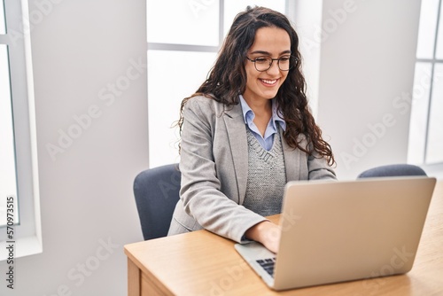 Young hispanic woman business worker using laptop working at office