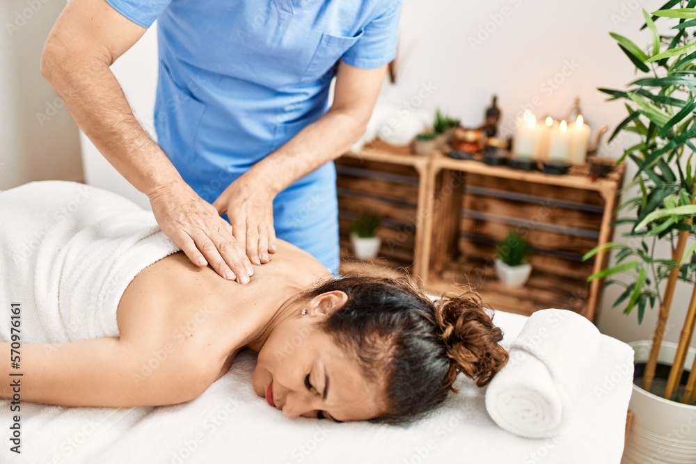 Middle age man and woman wearing therapist uniform having back massage session at beauty center Middle age man and woman wearing therapist uniform having back massage session at beauty center