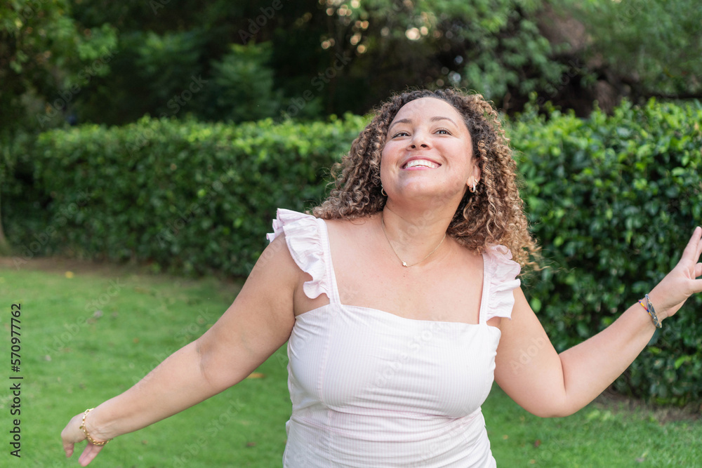 Curly haired woman happy and smiling with look of hope Curly haired woman happy and smiling with look of hope