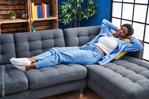 African american woman relaxing lying on sofa at home