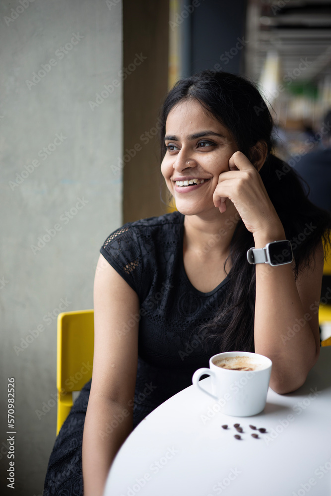 beautiful young woman drinking her Morning coffee by the window with a bright smile beautiful young woman drinking her Morning coffee by the window with a bright smile