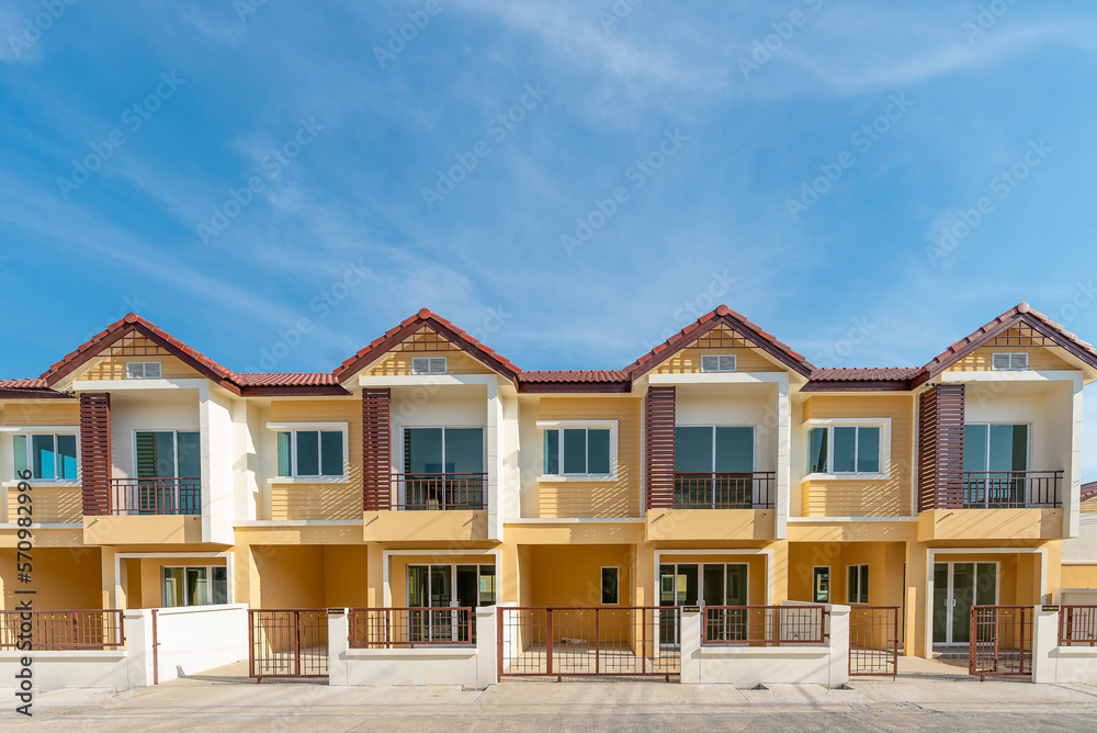The row of just finished new yellow townhouses, Front View of New Residential house, the architectural design of the exterior with blue sky and apace,The concept for Sale, Rent,Housing,and Real Estate