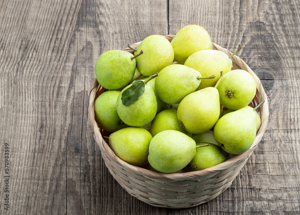 Juicy yellow pears in basket on wooden table Juicy yellow pears in basket on wooden table