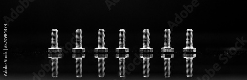 Industrial Fasteners and Tools. Steel Bolts closeup on black background with reflection. Panoramic banner. 