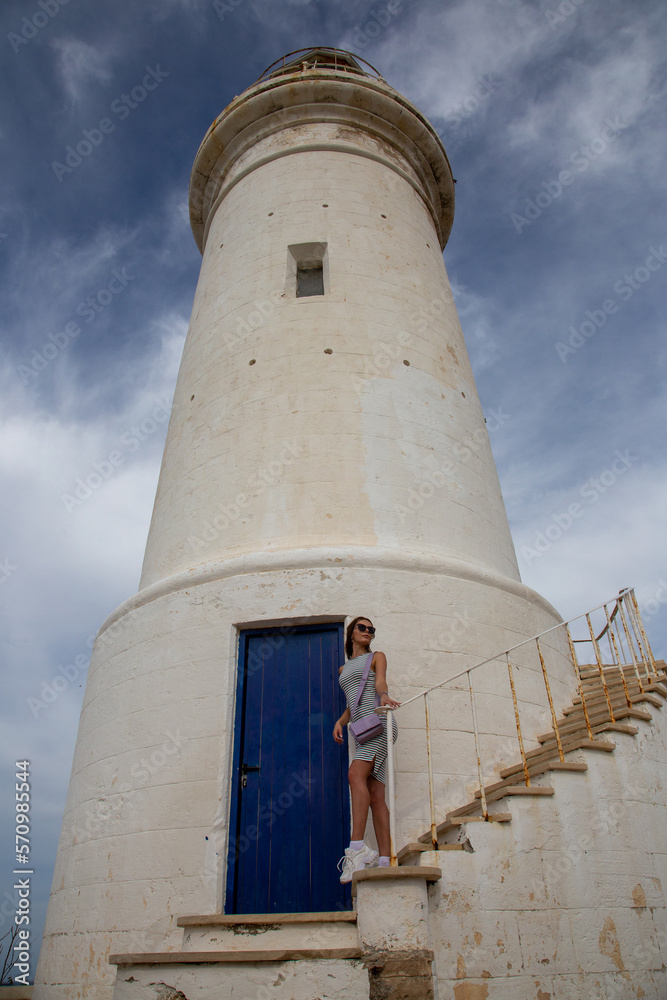 Tourist girl in front of the lighthouse in Paphos, Cyprus
