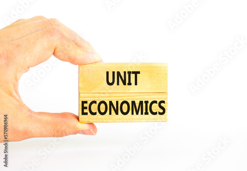 Unit economics symbol. Concept words Unit economics on wooden blocks. Beautiful white table white background. Businessman hand. Business and unit economics concept. Copy space.