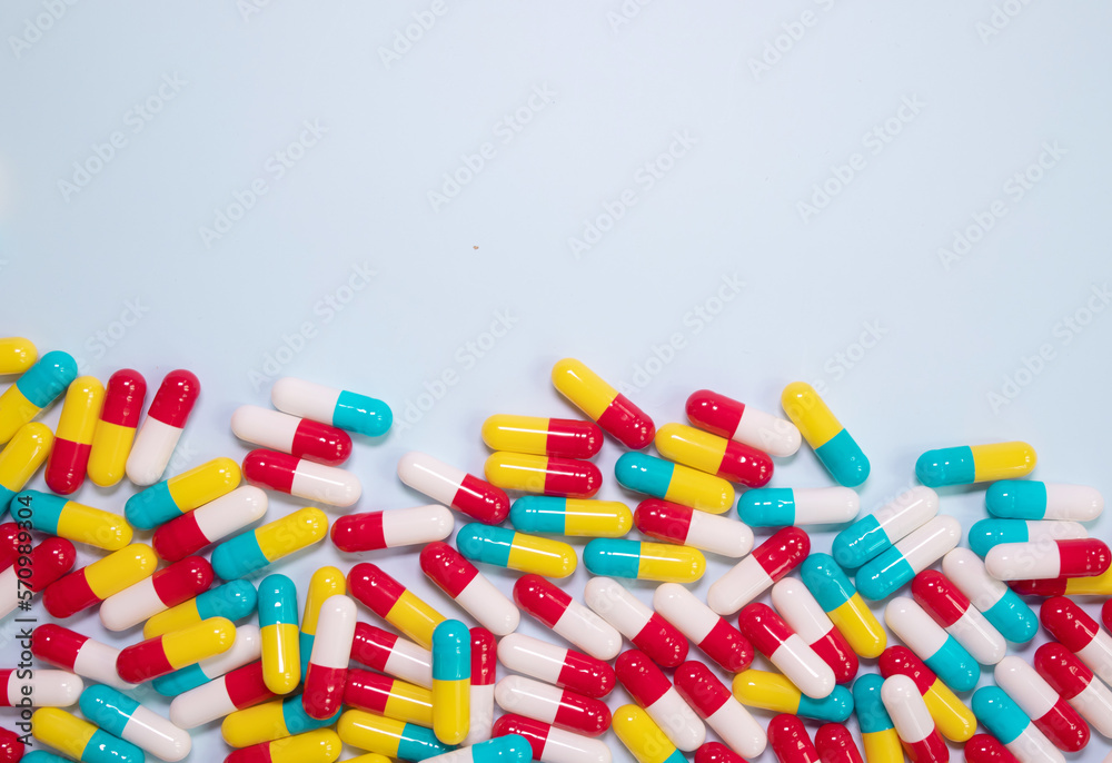 Creative layout of colorful pills and capsules on blue background. Minimal medical concept. Pharmaceutical, Medicine. Flat lay, top view.