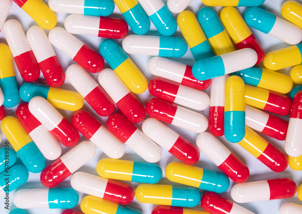 Creative layout of colorful pills and capsules on blue background. Minimal medical concept. Pharmaceutical, Medicine. Flat lay, top view. Creative layout of colorful pills and capsules on blue background. Minimal medical concept. Pharmaceutical, Medicine. Flat lay, top view.