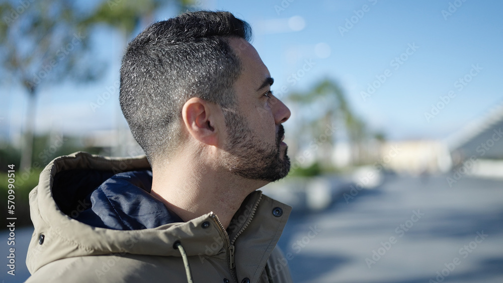 Young hispanic man looking to the side with serious expression at street Young hispanic man looking to the side with serious expression at street