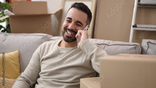 Young hispanic man smiling confident talking on smartphone at new home