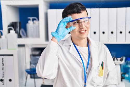 Young non binary man scientist smiling confident at laboratory