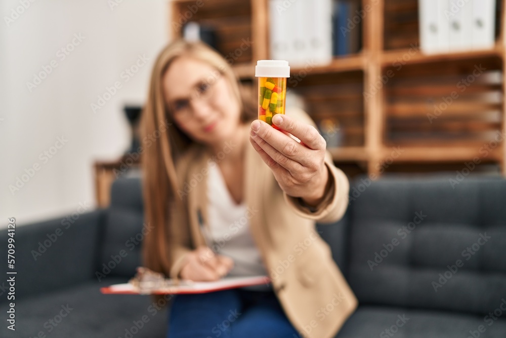 Young blonde woman psychologist prescribe pills at psychology clinic Young blonde woman psychologist prescribe pills at psychology clinic