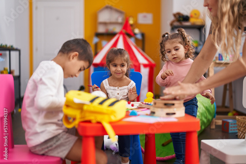 Group of kids preschool students sitting on table drawing on paper at kindergarten