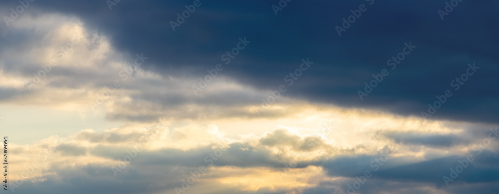 Dramatic sky with dark small clouds at sunset, panorama