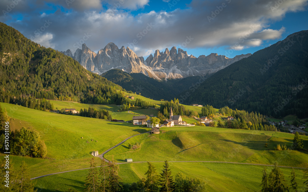 Panoramic of Santa Maddalena, Dolomites, Italy. Green valley landscape with snowy mountains in the background.