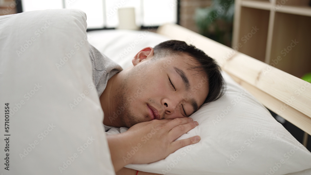 Young chinese man lying on bed sleeping at bedroom Young chinese man lying on bed sleeping at bedroom