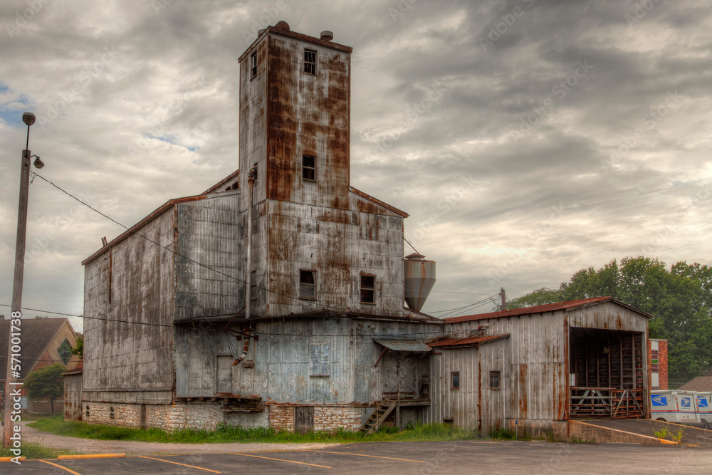 Fototapeta premium Old Rusty Grain Elevator against a sky with dramatic clouds 
