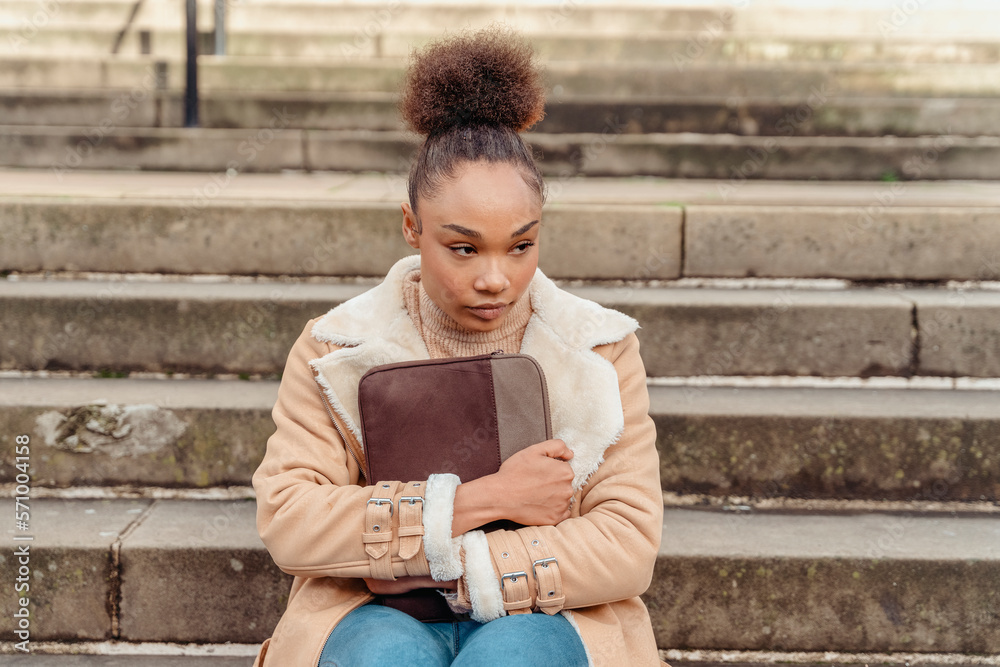 Obraz premium Upset woman student e-learning distance training course study working on stairs in the city. Multiethnic young woman watching online education webinar using a laptop