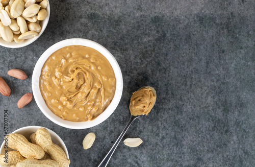 Crispy peanut butter in a bowl and peanuts on a gray background. Top view. Copy space.