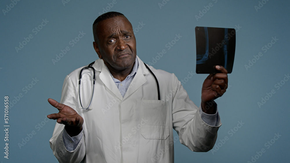 Mature serious man radiologist doctor examining x-ray check results scan looking pensive and focused upset male medic expert surgeon analyzes injury on tomography image makes bad diagnosis fracture Mature serious man radiologist doctor examining x-ray check results scan looking pensive and focused upset male medic expert surgeon analyzes injury on tomography image makes bad diagnosis fracture