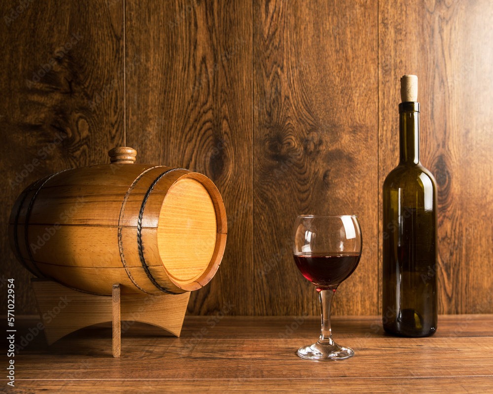 Barrel for wine and a bottle of wine with a glass