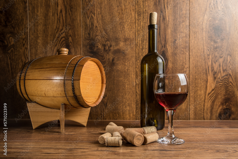 Barrel for wine and a bottle of wine with a glass
